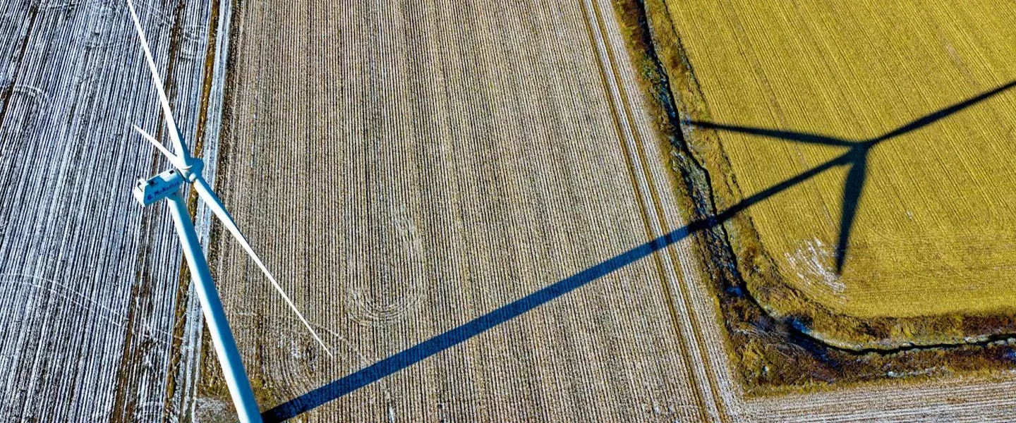 Vindkraftverk sett uppifrån över åkrar