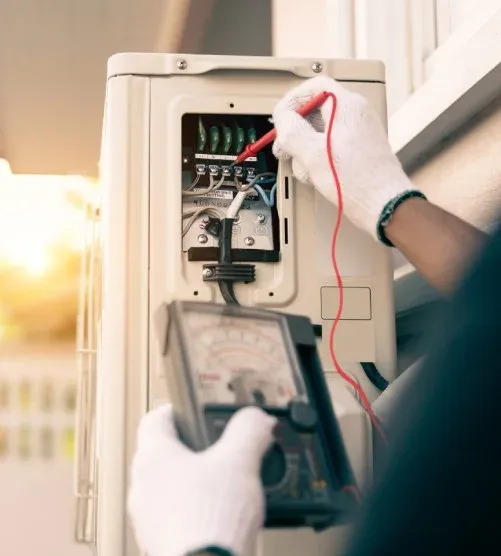 Elektriker mäter i ett elskåp med multimeter